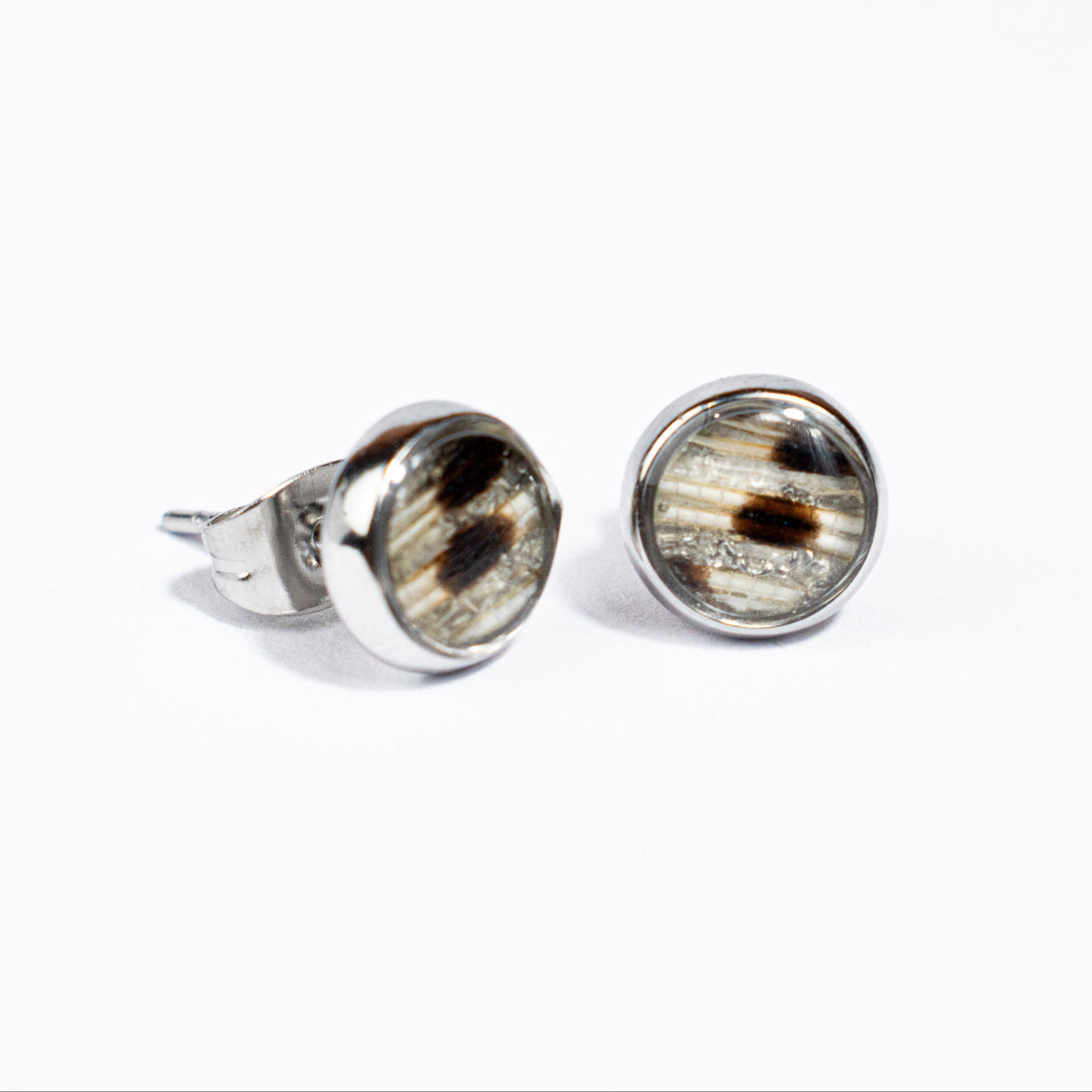 Pair of silver stud earrings with a lionfish pattern on a white background