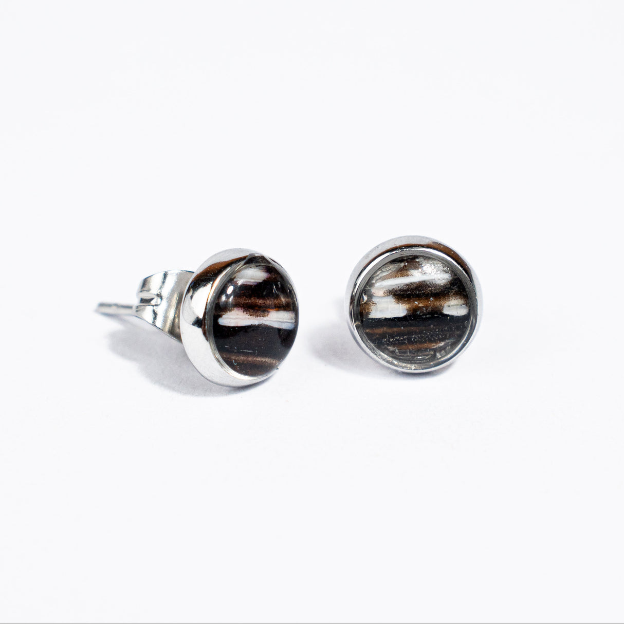 Pair of stainless steel silver setting and black and white lionfish fin stud earrings on a white background.