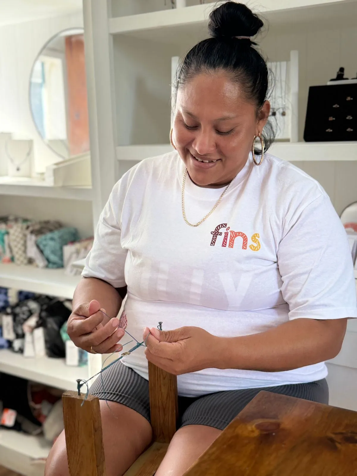 An artisan assembling jewelry in the FINS workshop