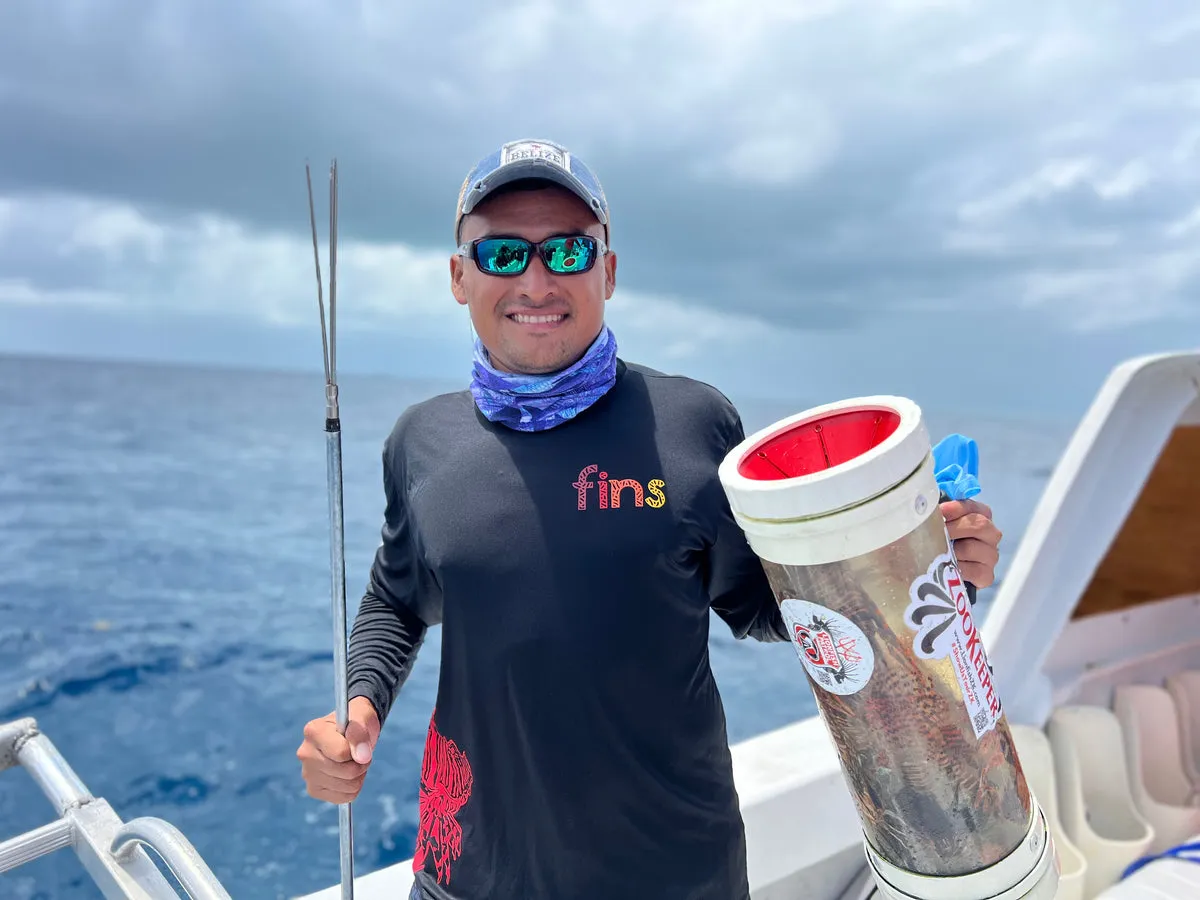 Willie Caal on the boat holding a lionfish containment tube
